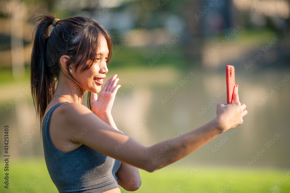 Beautiful asian girl dressd sporty outdoor in a city park taking selfies Beautiful asian girl dressd sporty outdoor in a city park taking selfies