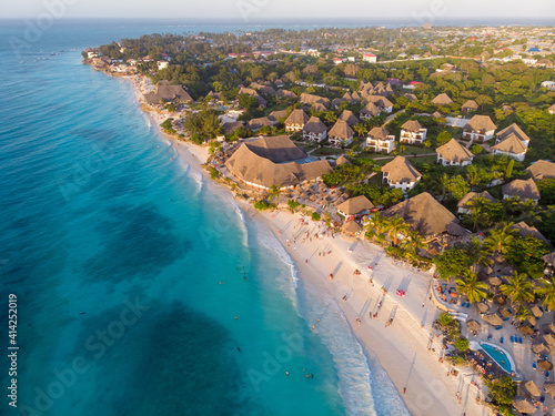 Aerial Shot on Zanzibar a beautiful sunset with people Walking on the Nungwi beach in Zanzibar in Tanzania