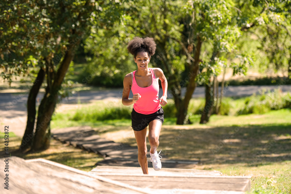 young metis woman running in a park young metis woman running in a park