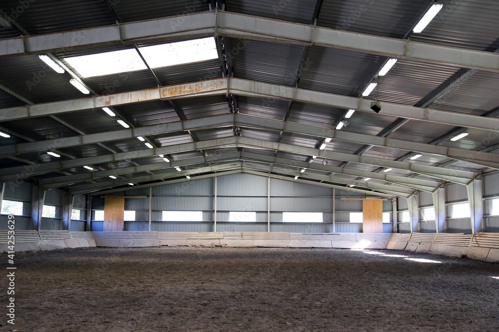 Photo of an empty indoor riding hall for horses and riders Photo of an empty indoor riding hall for horses and riders