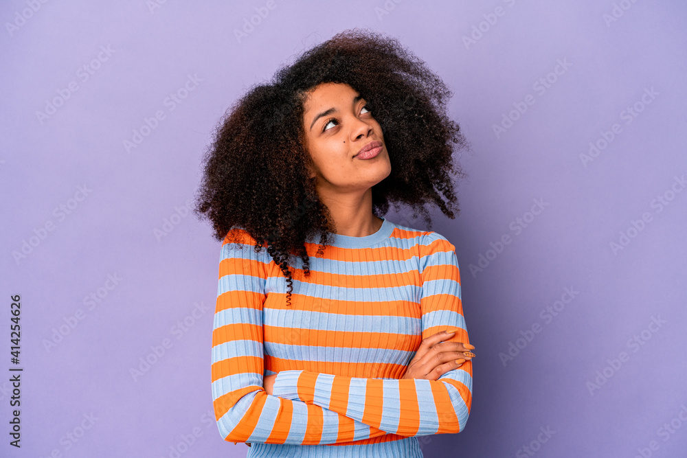Young african american curly woman isolated on purple background dreaming of achieving goals and purposes Young african american curly woman isolated on purple background dreaming of achieving goals and purposes