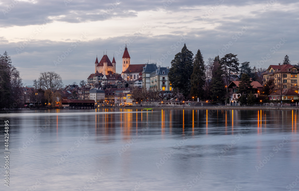 Fototapeta premium Thun city old town skyline with castle and church reflected in the aare river at night with illumination, canton bern switzerland.