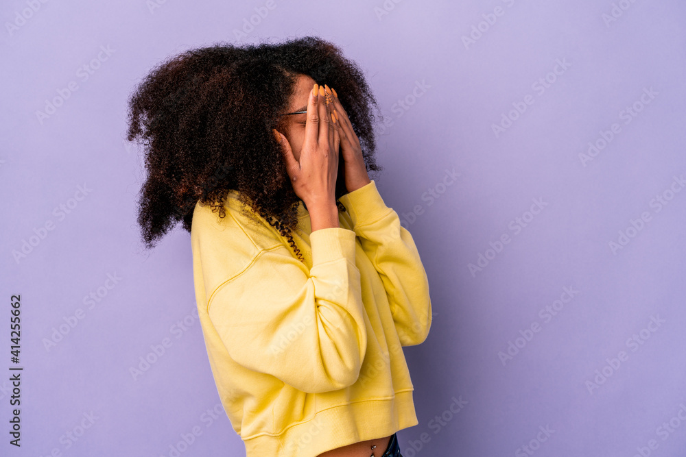 Young african american curly woman isolated on purple background afraid covering eyes with hands. Young african american curly woman isolated on purple background afraid covering eyes with hands.