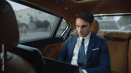 Aggressive businessman getting angry near laptop computer screen in modern car. © stockbusters
