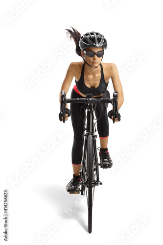 Sporty female riding a bicycle towards the camera