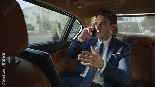 Focused business man talking on phone in interior of automobile. Man in car © stockbusters