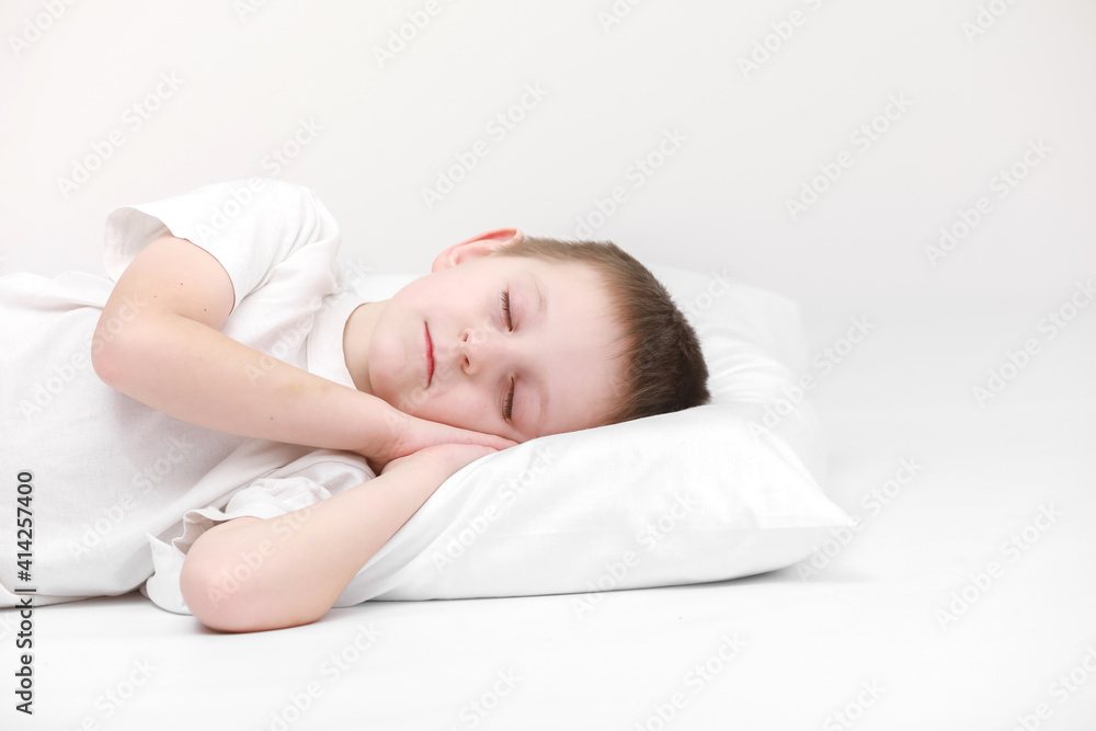 portrait of a cute little boy sleeping on a white pillow isolated on a white background. fresh and cozy bedding sheets. Bedtime for kids. concept of happy dreaming portrait of a cute little boy sleeping on a white pillow isolated on a white background. fresh and cozy bedding sheets. Bedtime for kids. concept of happy dreaming