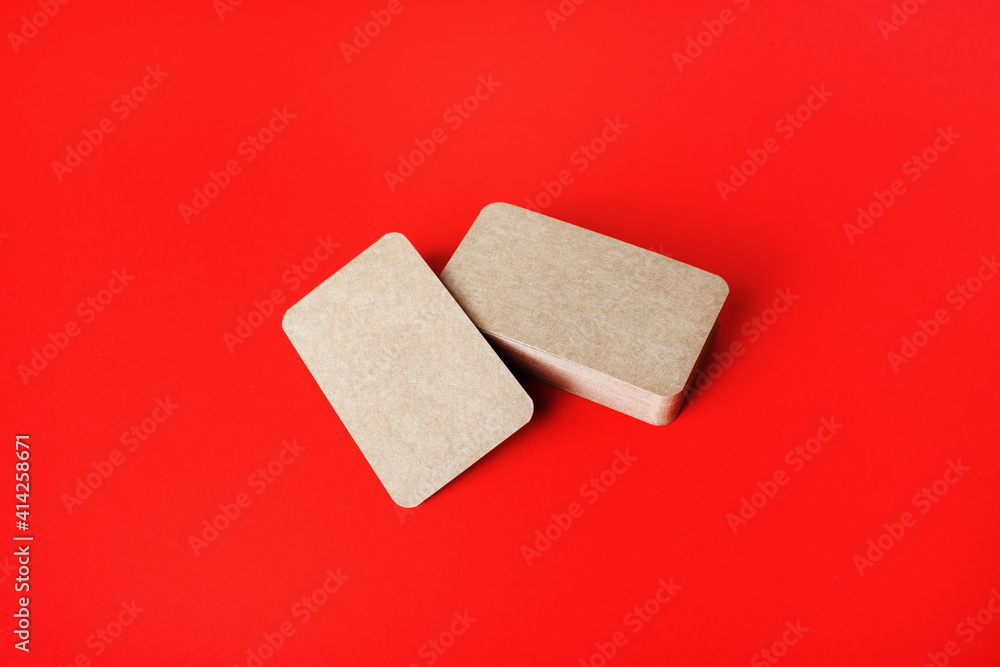 Blank kraft business cards on red paper background. Blank template for branding identity. Blank kraft business cards on red paper background. Blank template for branding identity.