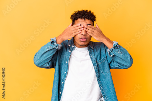 Young african american curly man isolated on purple afraid covering eyes with hands.