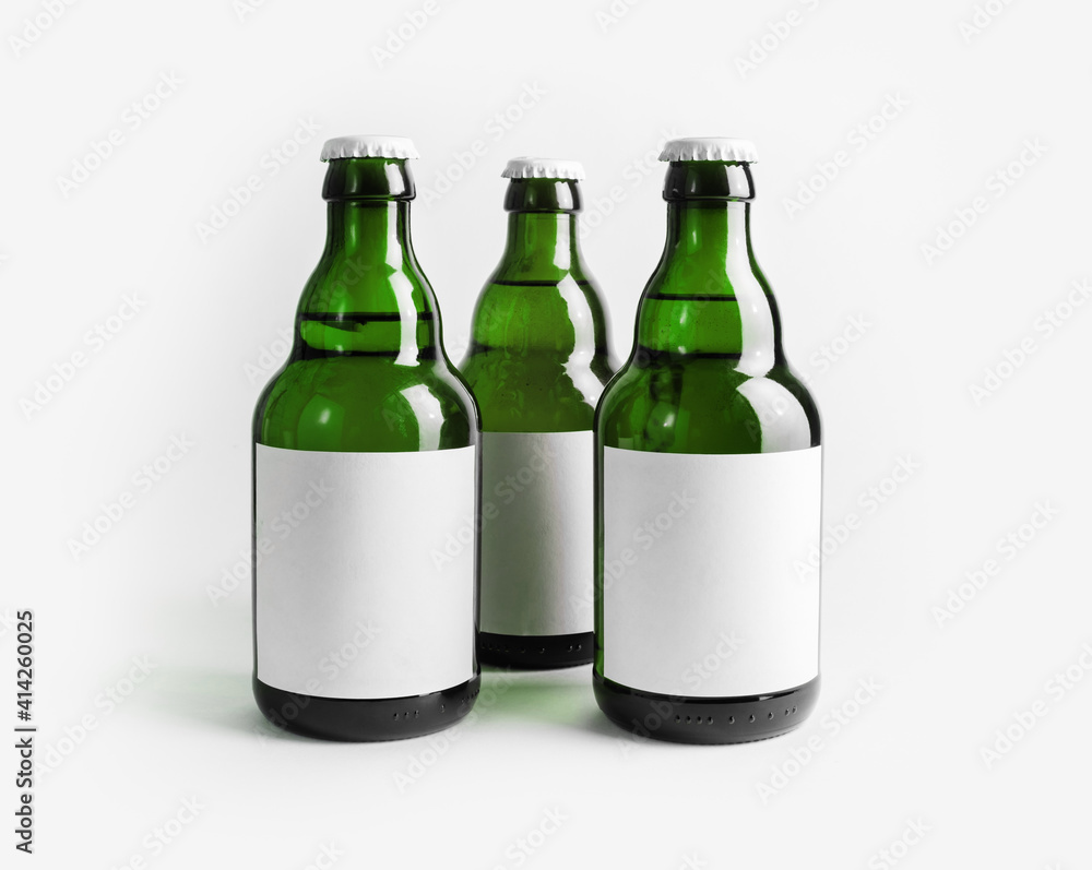 Three green beer bottles with blank labels. Three green beer bottles with blank labels.