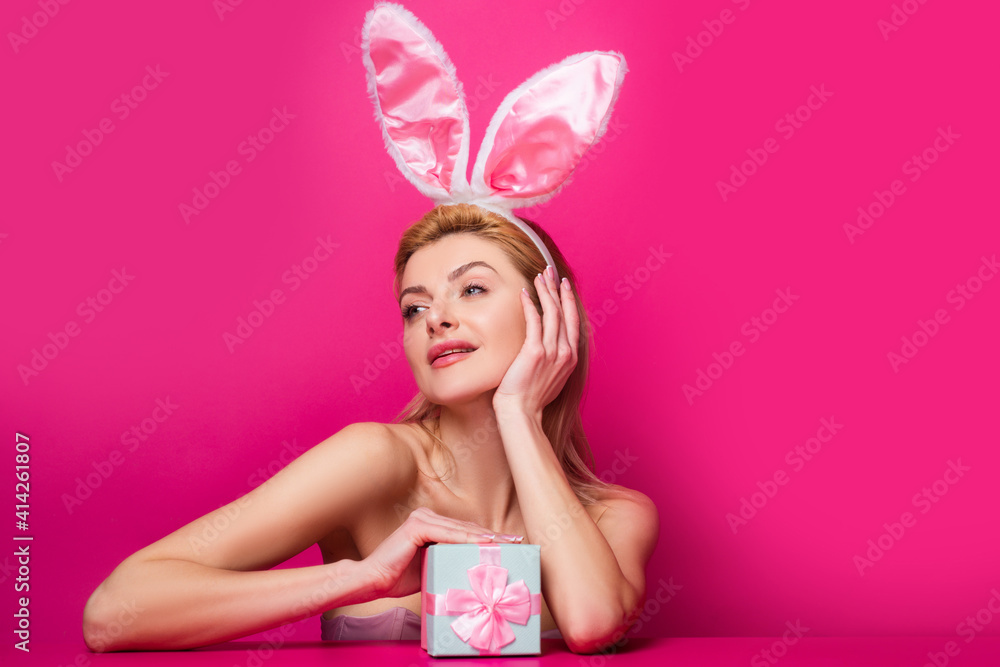 Beautiful young sexy bunny woman with prasent gift isolated on pink. Beautiful young sexy bunny woman with prasent gift isolated on pink.