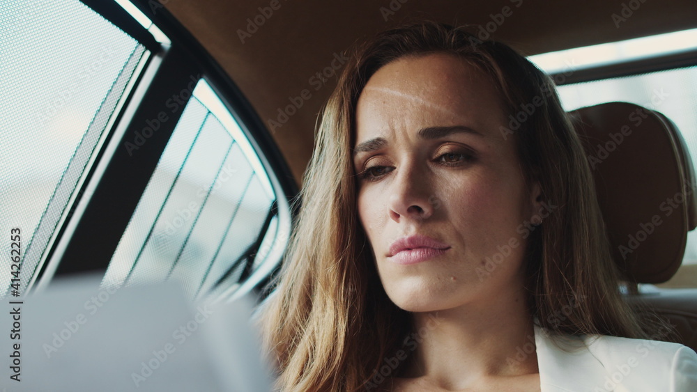Portrait of focused business lady looking at papers with data in business car. Portrait of focused business lady looking at papers with data in business car.