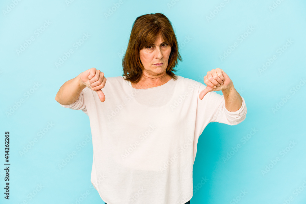 Senior caucasian woman isolated showing a dislike gesture, thumbs down. Disagreement concept. Senior caucasian woman isolated showing a dislike gesture, thumbs down. Disagreement concept.