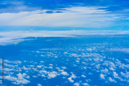 Landscape of fluffy white clouds on a dark blue sky. View from the plane at high altitude © Kate