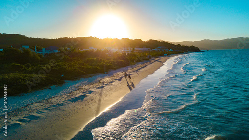 Por do sol na praia com ondas © Marcelo