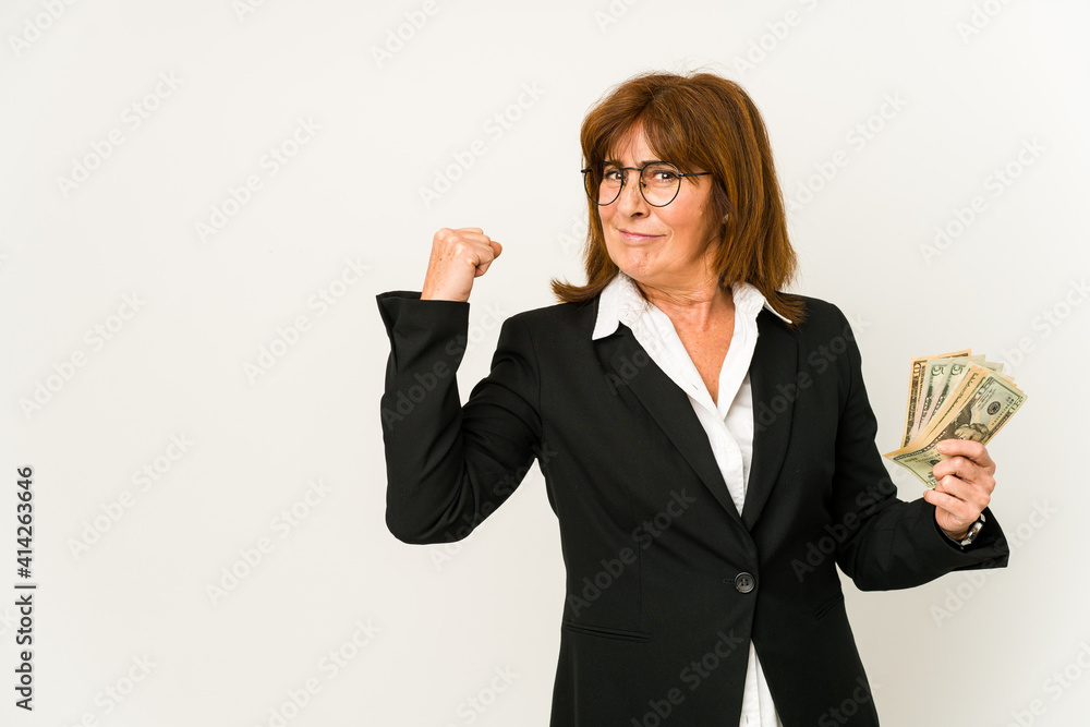Middle age caucasian business woman holding banknotes isolated raising fist after a victory, winner concept. Middle age caucasian business woman holding banknotes isolated raising fist after a victory, winner concept.