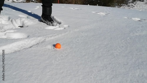 golfswing at wintertime with snow and a red ball photo
