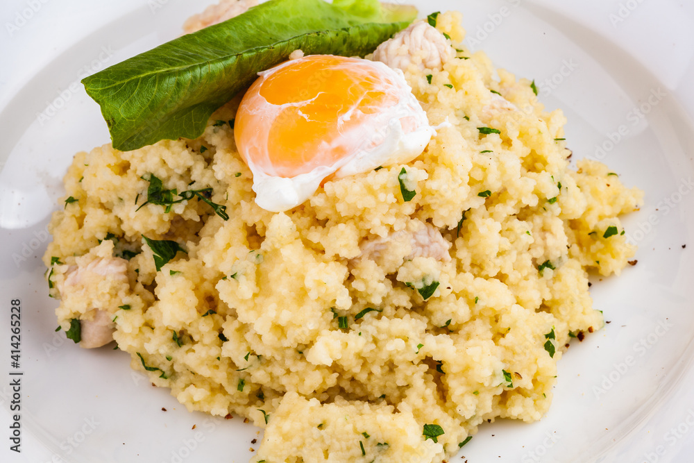 Couscous with chicken and egg on a white plate Couscous with chicken and egg on a white plate