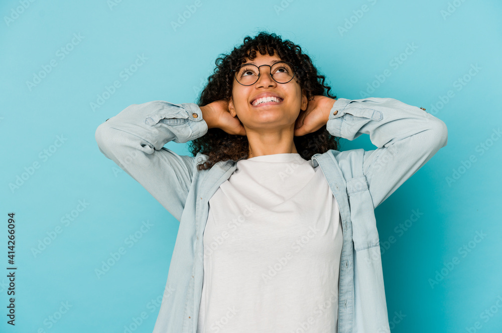 Young african american afro woman isolated feeling confident, with hands behind the head. Young african american afro woman isolated feeling confident, with hands behind the head.