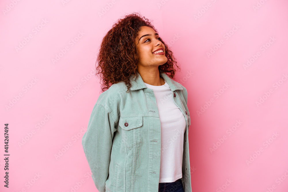 Young african american woman isolated on pink background relaxed and happy laughing, neck stretched showing teeth. Young african american woman isolated on pink background relaxed and happy laughing, neck stretched showing teeth.