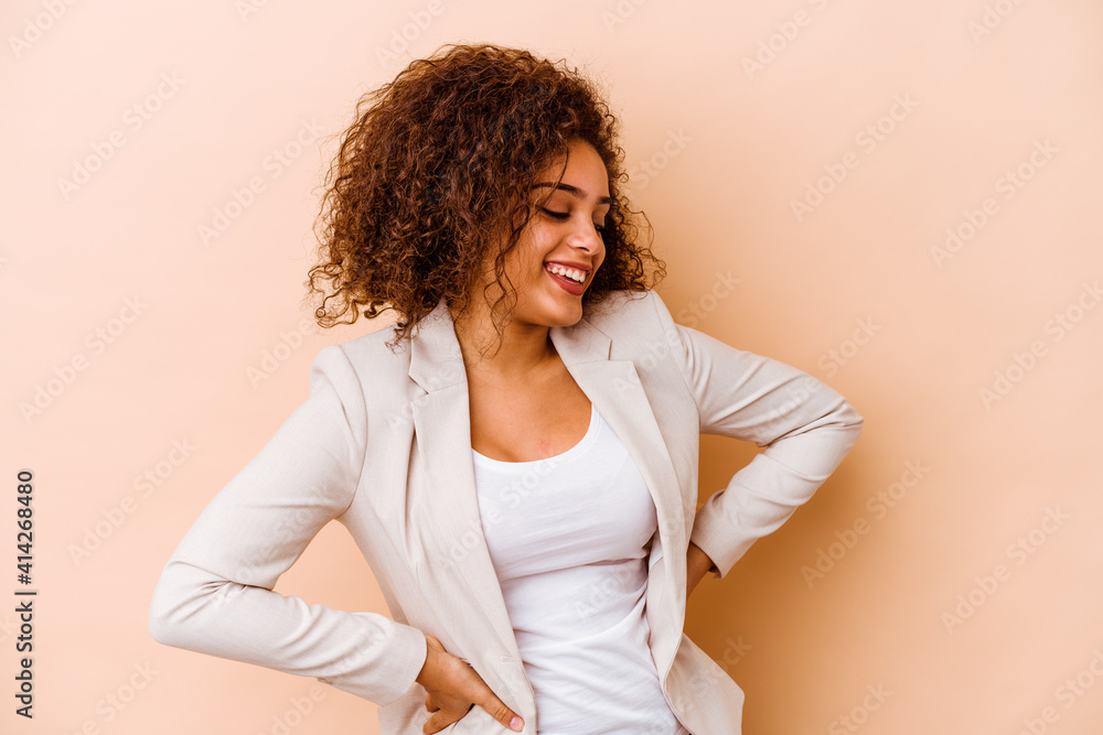 Young african american woman isolated on beige background confident keeping hands on hips. Young african american woman isolated on beige background confident keeping hands on hips.