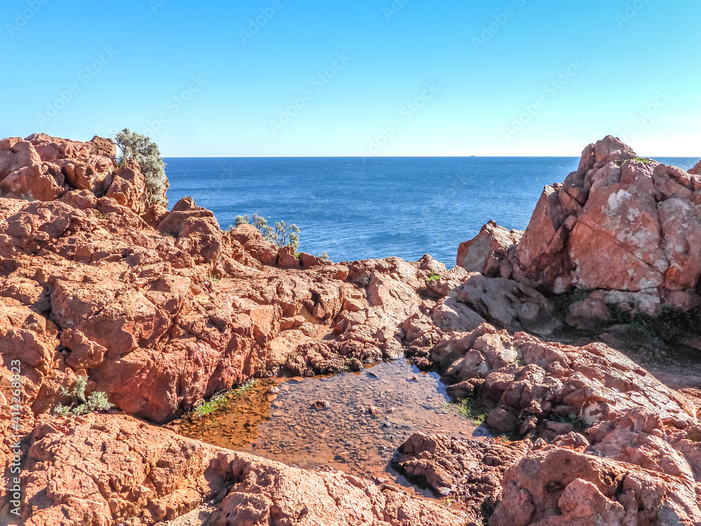 Plan d'eau dans les roches ocres en bord de mer