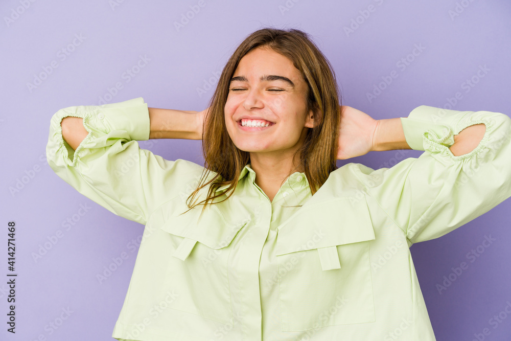 Young skinny caucasian girl teenager on purple background feeling confident, with hands behind the head. Young skinny caucasian girl teenager on purple background feeling confident, with hands behind the head.