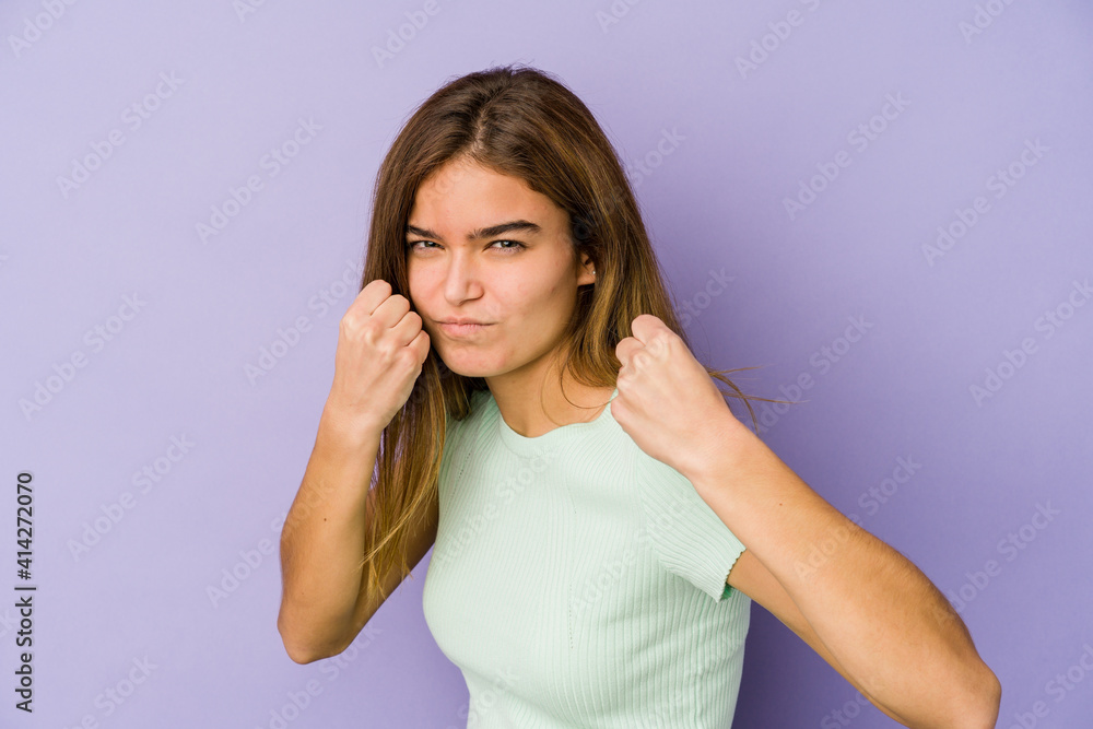 Young skinny caucasian girl teenager on purple background showing fist to camera, aggressive facial expression. Young skinny caucasian girl teenager on purple background showing fist to camera, aggressive facial expression.