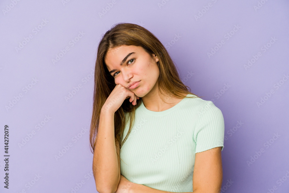 Young skinny caucasian girl teenager on purple background tired of a repetitive task. Young skinny caucasian girl teenager on purple background tired of a repetitive task.