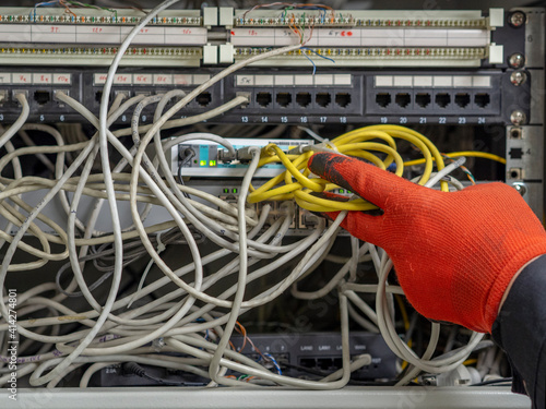 A man holds a pair of scissors and cuts the Internet cable (electrical wire) of the data server. The concept of blocking Computer Network, telecommunications broadcast, information technology.