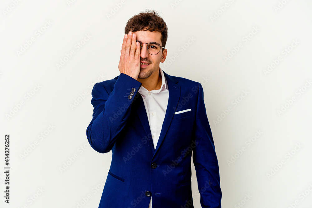Young business caucasian man isolated on white background having fun covering half of face with palm.