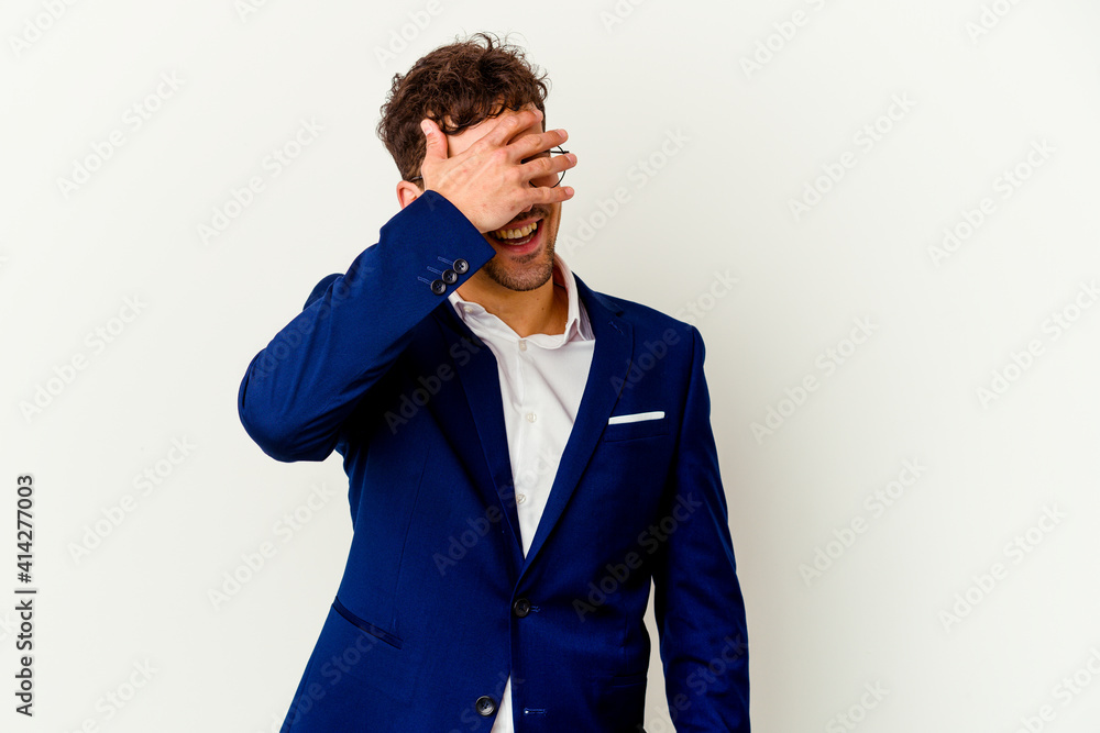 Young business caucasian man isolated on white background covers eyes with hands, smiles broadly waiting for a surprise. Young business caucasian man isolated on white background covers eyes with hands, smiles broadly waiting for a surprise.