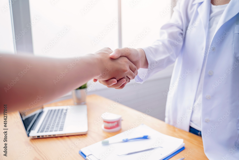 Close up female dentist doctor greeting shaking hands with Asian woman patient, dental hygiene healthcare professional expert orthodontist specialist, working hospital modern meeting room office Close up female dentist doctor greeting shaking hands with Asian woman patient, dental hygiene healthcare professional expert orthodontist specialist, working hospital modern meeting room office