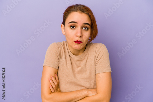 Young arab mixed race woman shrugs shoulders and open eyes confused.