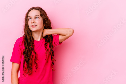 Little caucasian girl isolated on pink background touching back of head  thinking and making a choice.