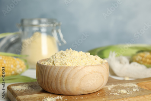 Corn flour in bowl on wooden board