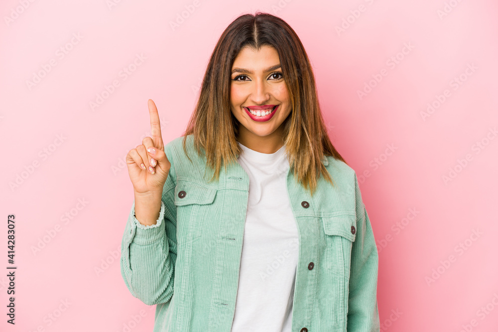 Young indian woman isolated on pink background showing number one with finger. Young indian woman isolated on pink background showing number one with finger.