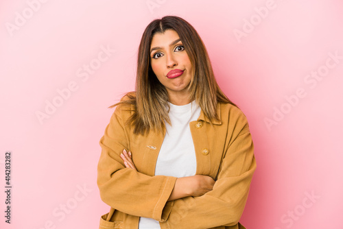 Young indian woman isolated on pink background who is bored, fatigued and need a relax day.