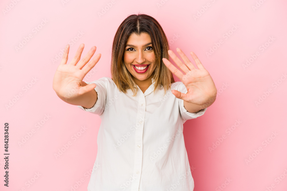 Young indian woman isolated on pink background showing number ten with hands. Young indian woman isolated on pink background showing number ten with hands.