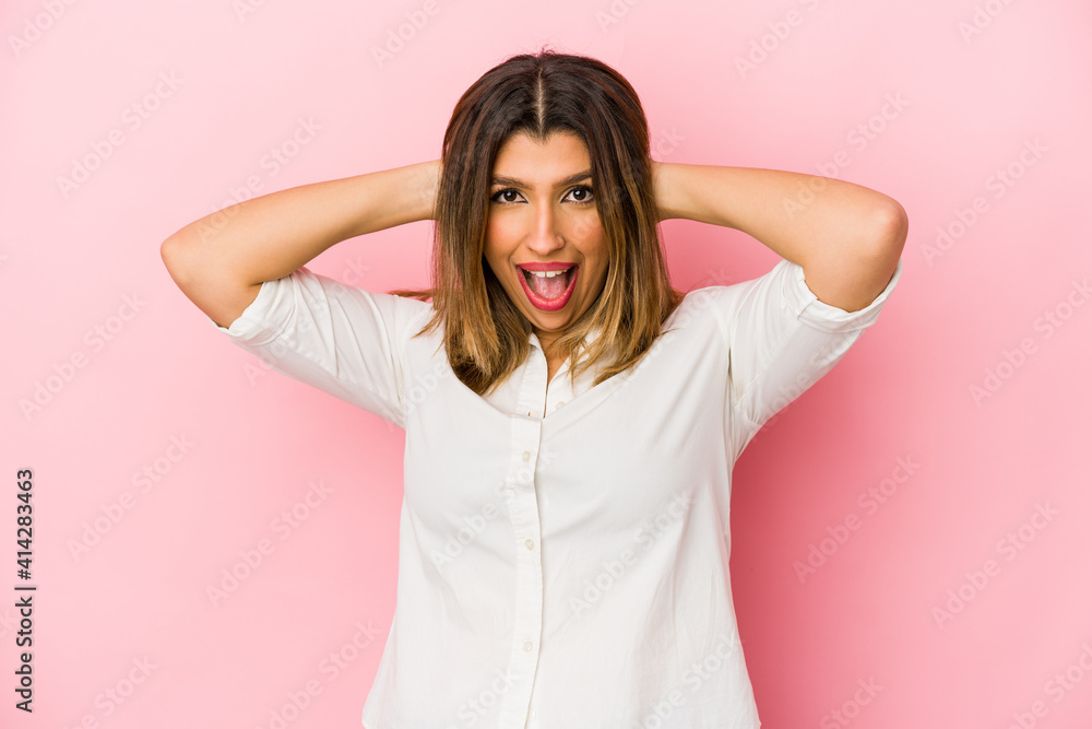 Young indian woman isolated on pink background screaming, very excited, passionate, satisfied with something. Young indian woman isolated on pink background screaming, very excited, passionate, satisfied with something.