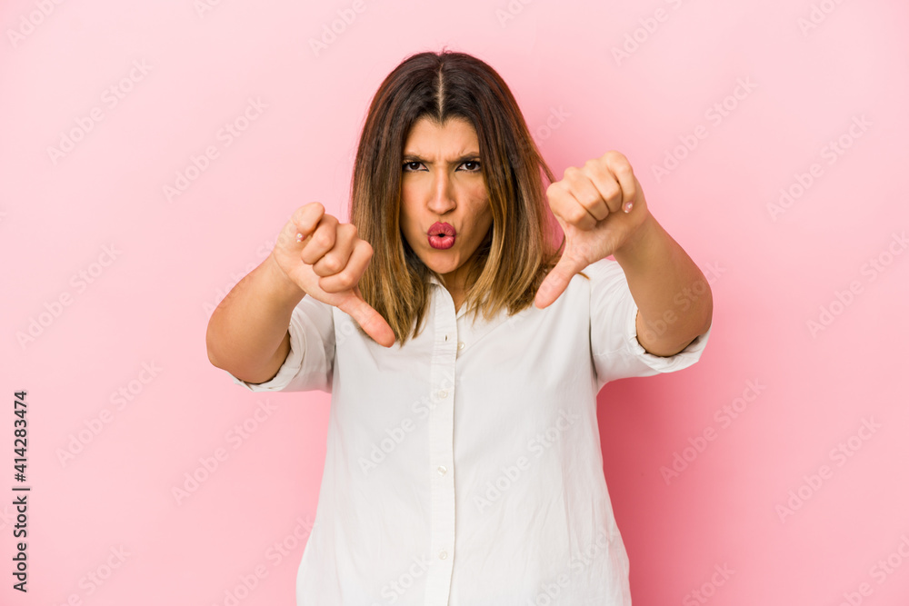 Young indian woman isolated on pink background showing thumb down and expressing dislike.