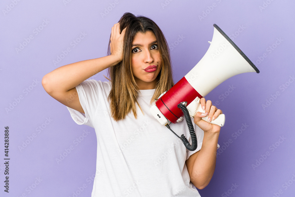Young indian woman holding a megaphone isolated being shocked, she has remembered important meeting. Young indian woman holding a megaphone isolated being shocked, she has remembered important meeting.