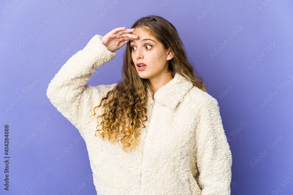 Young caucasian cute woman looking far away keeping hand on forehead. Young caucasian cute woman looking far away keeping hand on forehead.