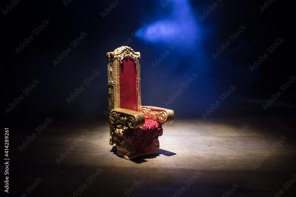 Red royal chair miniature on wooden table. Place for the king. Medieval Throne.