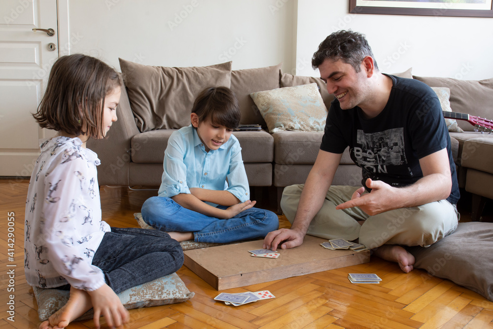 Fototapeta premium dad and kids playing and learning card games. 