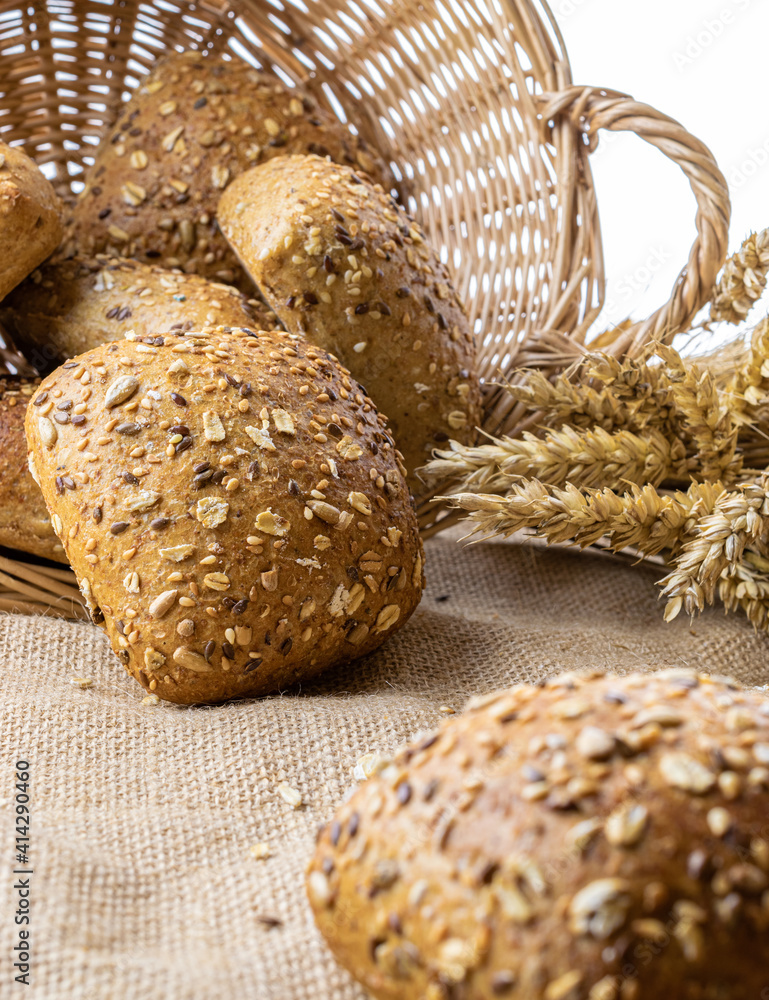 Baguette bread. Rye bakery with crusty loaves and crumbs. Fresh loaf of rustic traditional bread with wheat grain ear or spike plant on natural cotton background. Concept - Cooking at Home. Baguette bread. Rye bakery with crusty loaves and crumbs. Fresh loaf of rustic traditional bread with wheat grain ear or spike plant on natural cotton background. Concept - Cooking at Home.