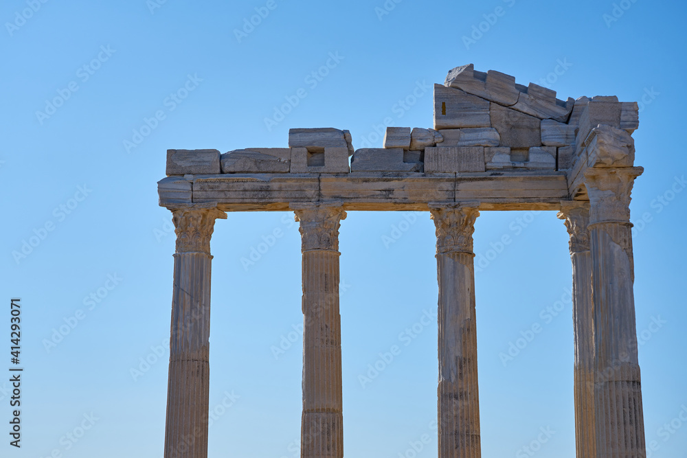 The ruins of the Apollo temple in Side, Turkey against a blue sky.