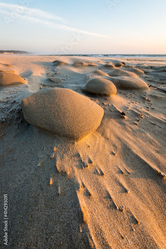 Wind blown sand forming fantastic natural shapes along the beach next to the Pacific Ocean in Oregon photo