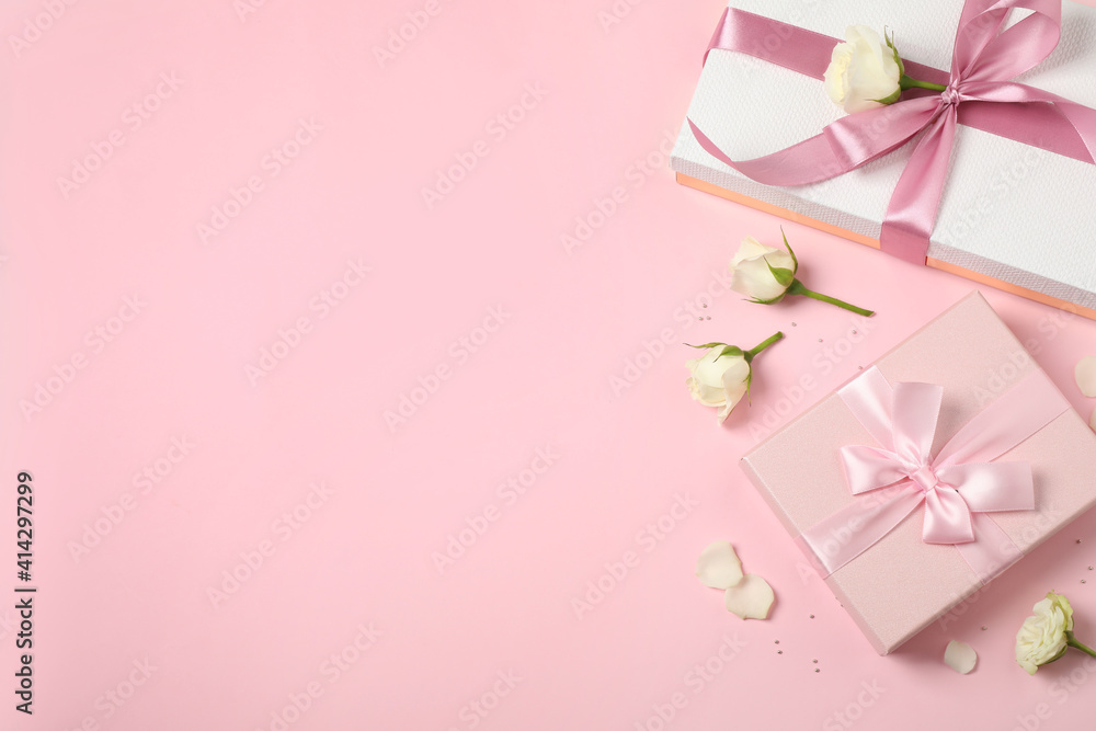 Elegant gift boxes and beautiful flowers on pink background, flat lay. Space for text