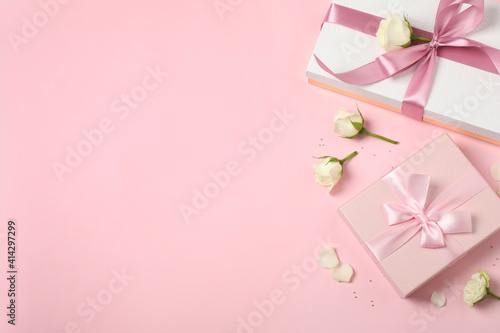 Elegant gift boxes and beautiful flowers on pink background  flat lay. Space for text